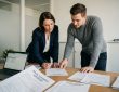 Agent immobilier et locataire signant un contrat de garantie de loyer dans une agence immobilière suisse